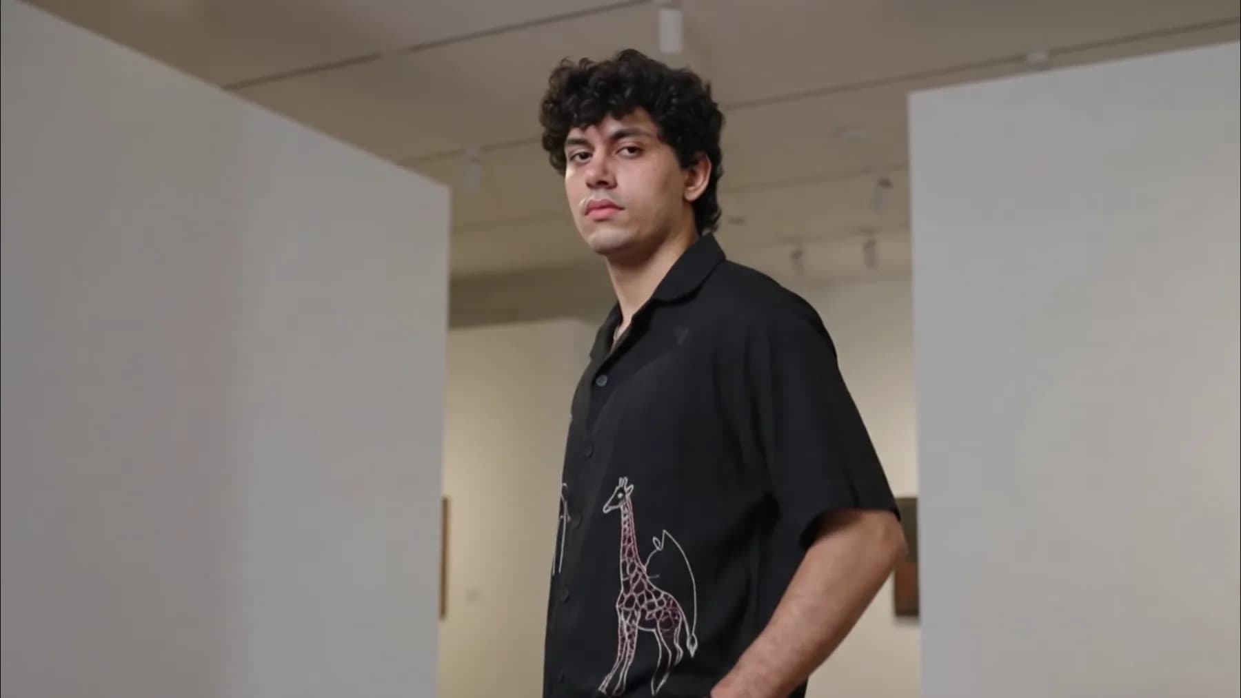 The line art camp collar shirt in black, worn open and cut boxy away from the body